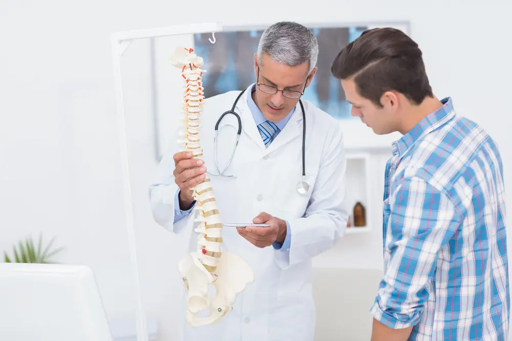 osteopathic doctor explaining back pain symptoms to patient