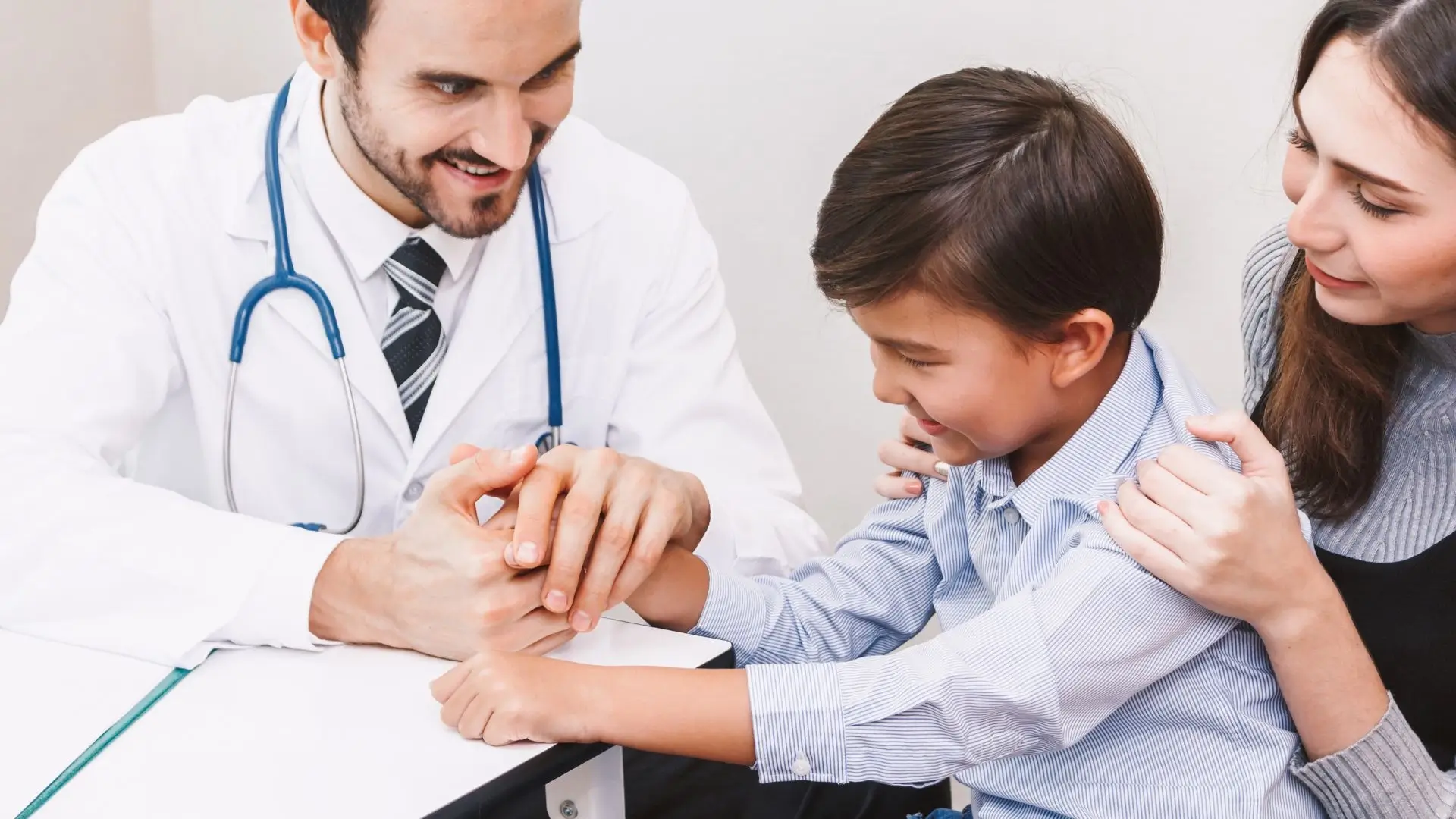 A doctor with a kid patient with his mom